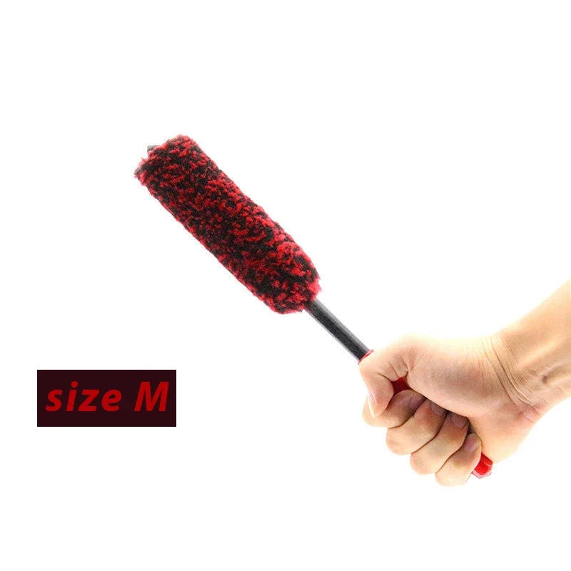 A hand holds a red wool cleaning brush with a black handle, demonstrating the size M brush.