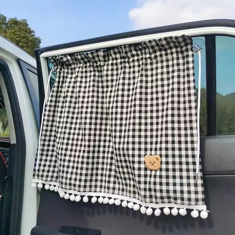 Visera de coche a cuadros blanco y negro con un pequeño dije de oso.