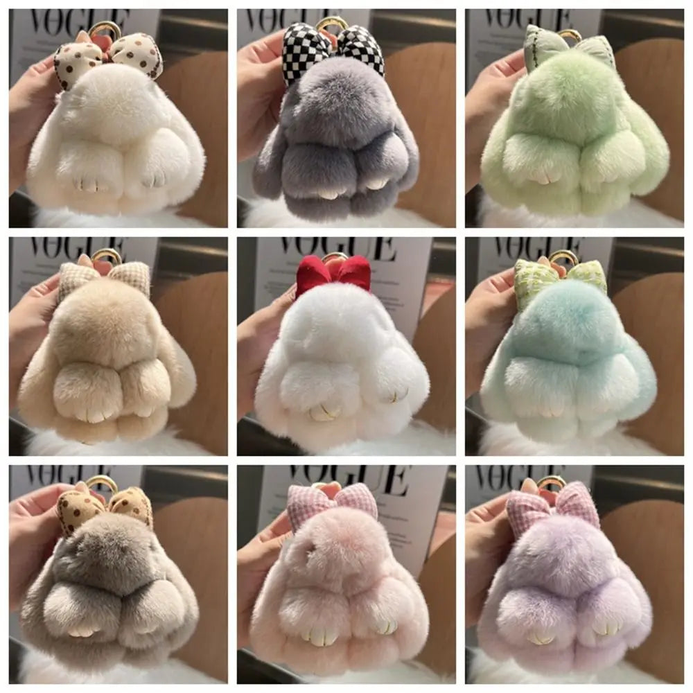 A collection of plush bunny keychains in various soft fur colors including white, gray, pink, and mint green.