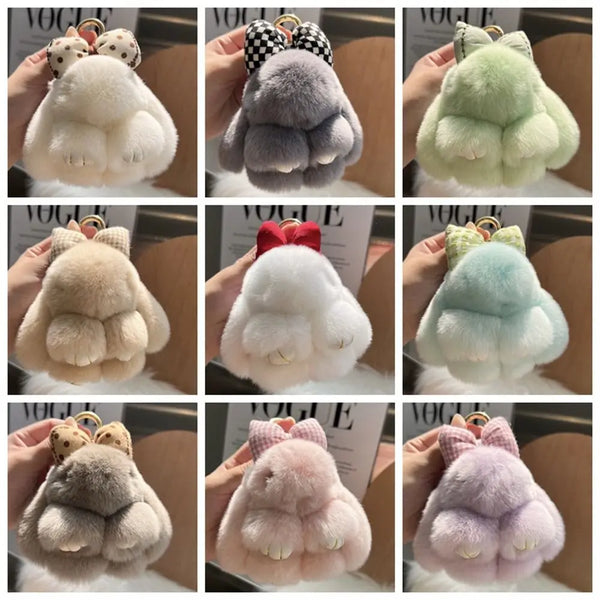 A collection of plush bunny keychains in various soft fur colors including white, gray, pink, and mint green.