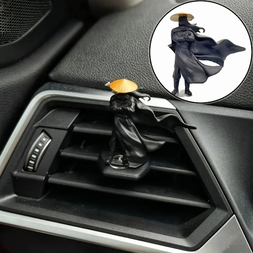 A black samurai statue with an orange hat is displayed in a slot on a car interior panel.
