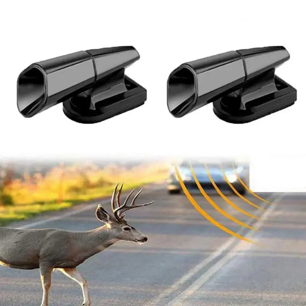 A pair of black ultrasonic car deer whistle repellers shown next to a deer in an outdoor setting.