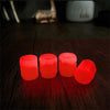 Une rangée de bouchons de valve rouges lumineux et éclatants sur une surface en bois sombre.