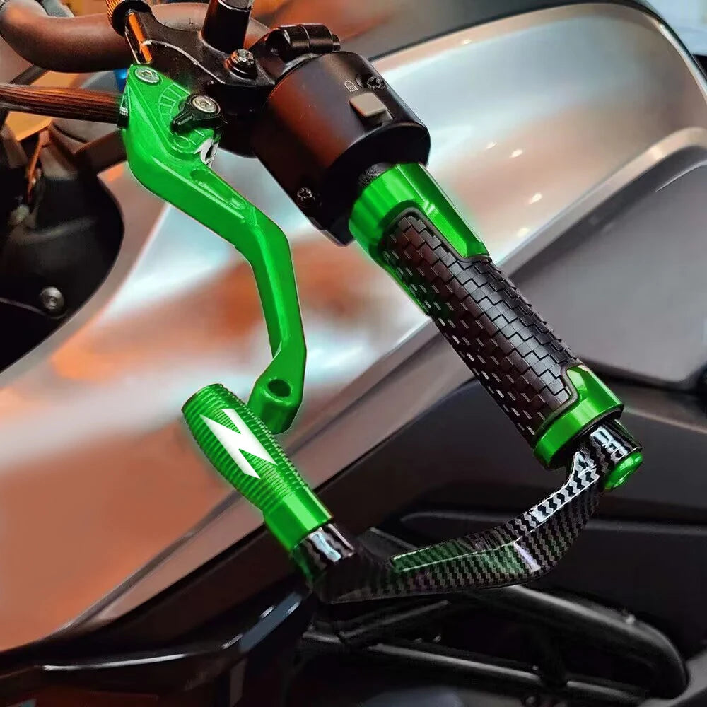 A close-up of a motorcycle lever and handguard protector kit with green grips and black components.