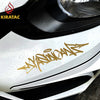 Nahaufnahme des silbernen Auto-Karosseries mit goldenen Wildstyle-Graffiti-Vinylaufklebern auf dem Stoßfänger.