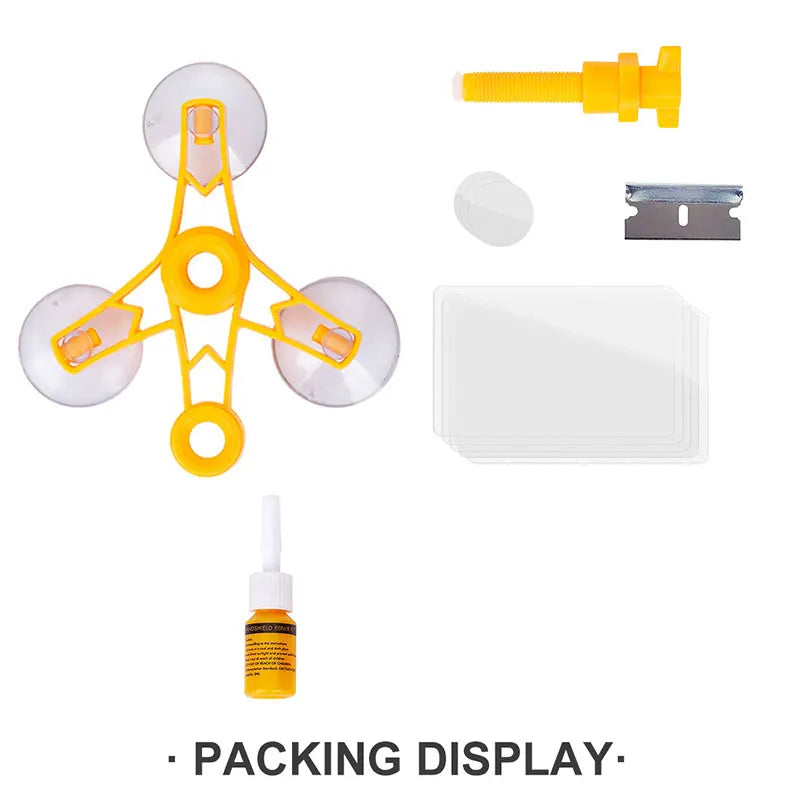 A set of car windshield repair tools including a yellow plastic tool, a metal piece, and a white adhesive pad.