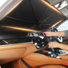 Une main ajuste un pare-soleil rétractable de voiture à l'intérieur de l'habitacle.