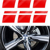 Red reflective safety stickers applied to a black alloy wheel rim.