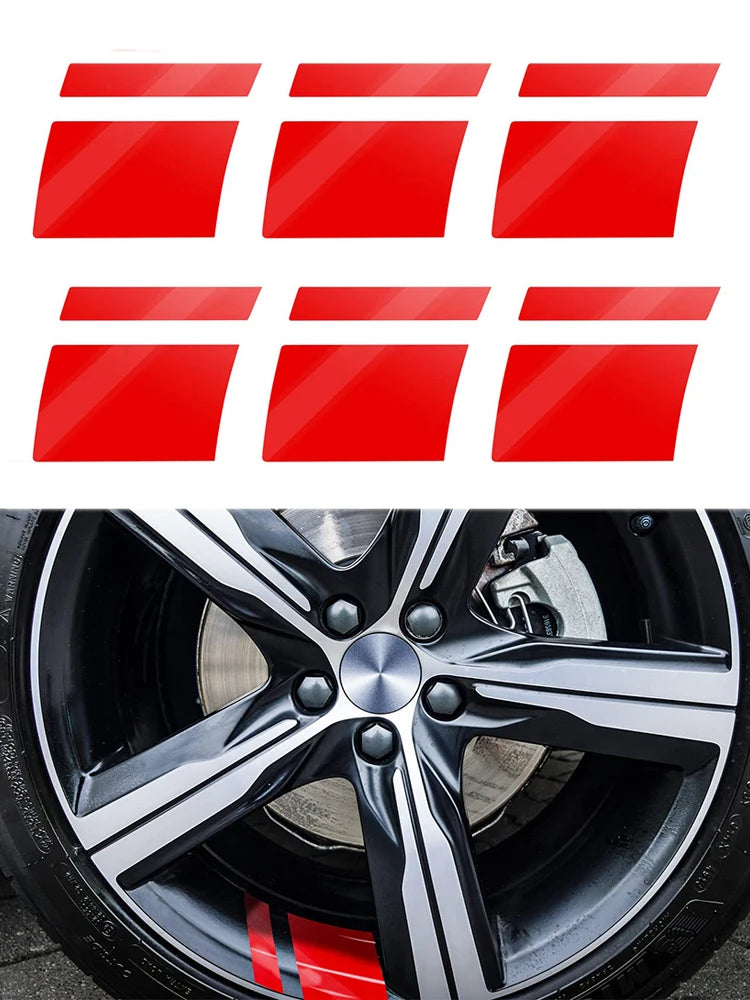 Red reflective safety stickers applied to a black alloy wheel rim.