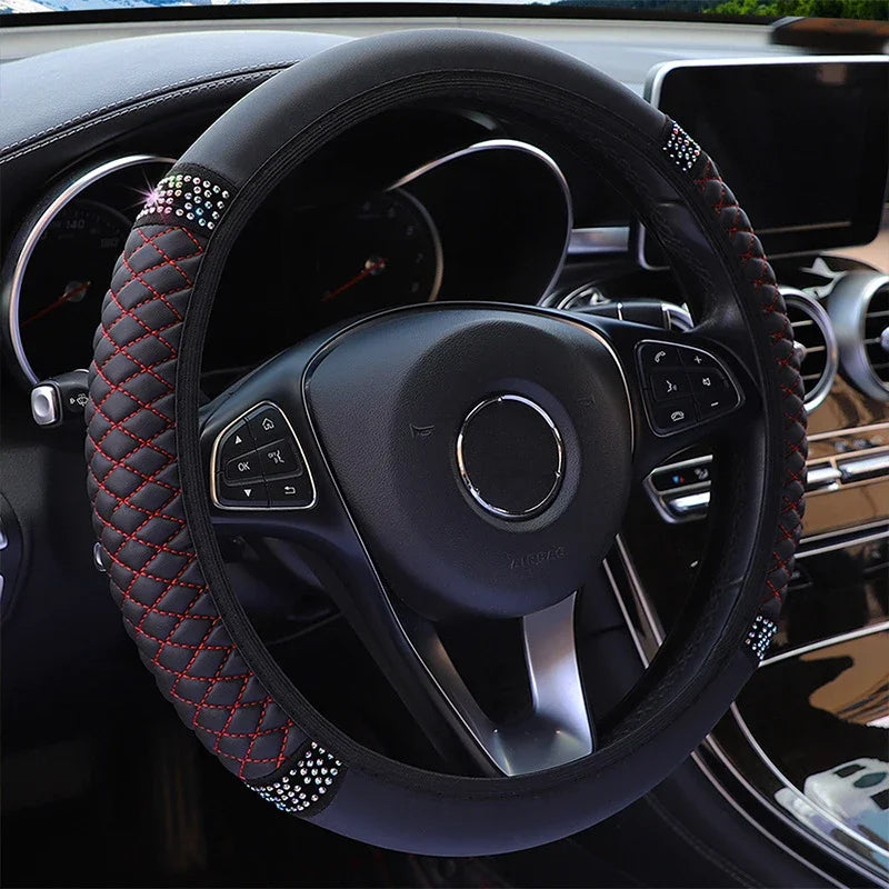 Close-up view of a black leather steering wheel with red stitching and silver accents inside a car
