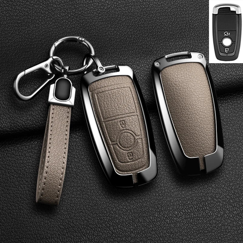 A black aluminum alloy key fob cover for a Ford vehicle, shown with a leather strap and a separate remote.