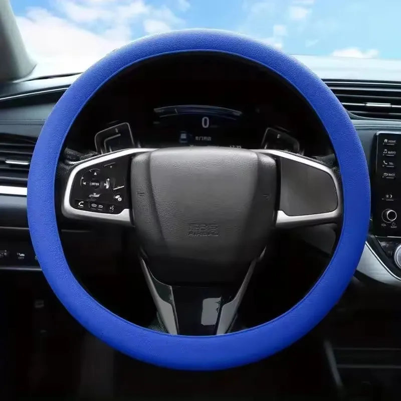 A close-up view of a blue silicone steering wheel cover on a car's steering wheel.