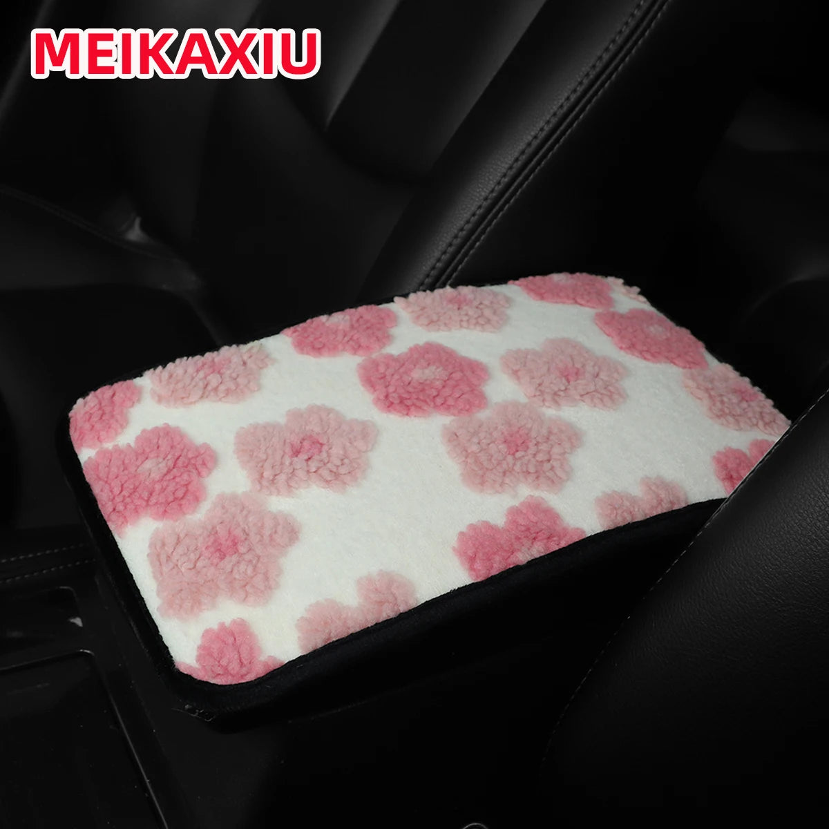 Pink and red plush car armrest cushion placed in a black car interior.