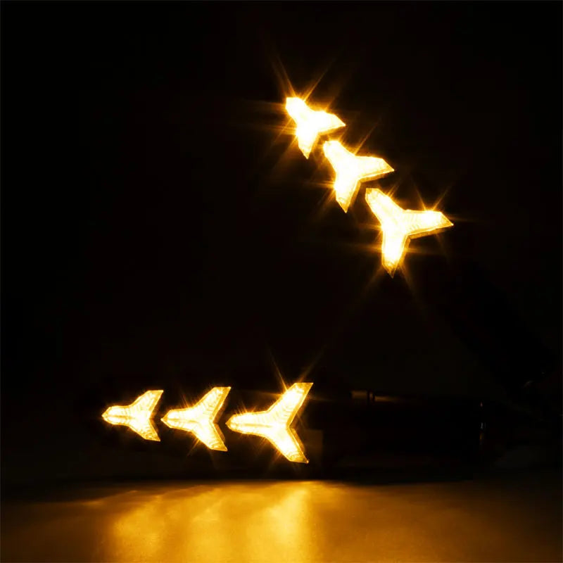Flowing LED motorcycle turn signals shining brightly against a dark background.
