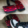 A set of red and black aluminum car pedal covers for sports pedals.