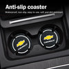 A close-up view of a car anti-slip coaster set with Chevrolet branded coasters inside the cup holder.