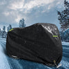 Black motorcycle cover with night reflective strips lying on a snowy road.