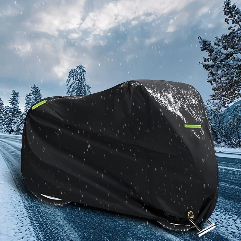 Black motorcycle cover with night reflective strips lying on a snowy road.