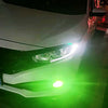 Close-up of a car headlight with a bright lemon green fog light activated.