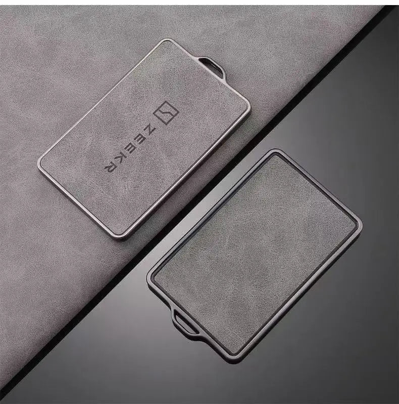 Un support de housse NFC argentée élégante posé sur une surface en tissu gris foncé.