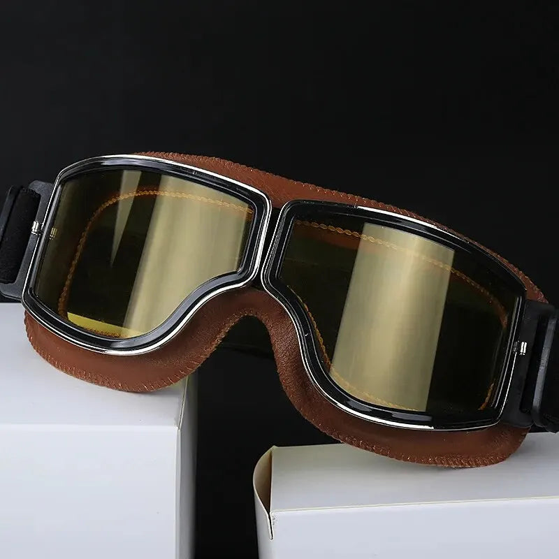 A pair of brown retro folding motorcycle windproof glasses resting on a white box.