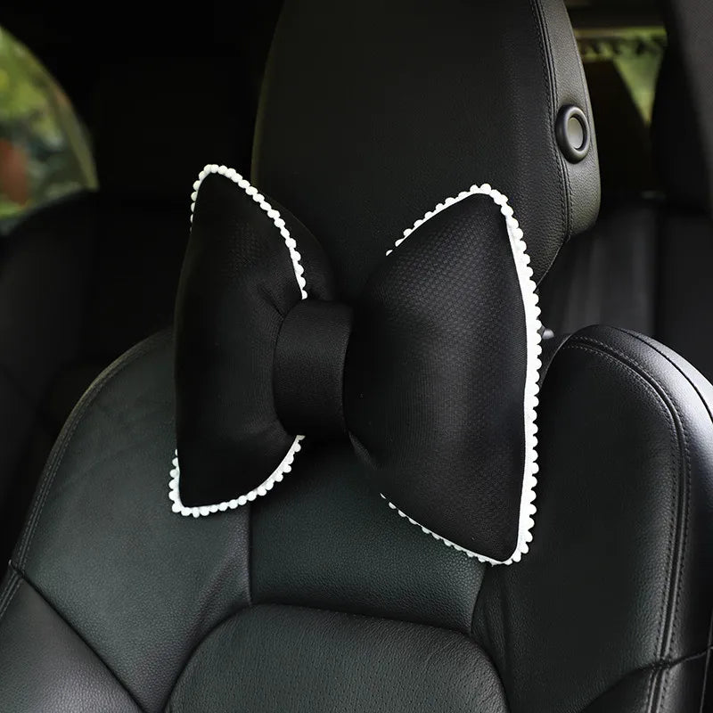 Black ergonomic car headrest pillow featuring a decorative bow design.