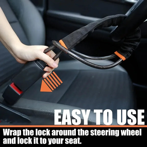 A hand is wrapping a black and orange strap around a steering wheel to secure it to a car seat.