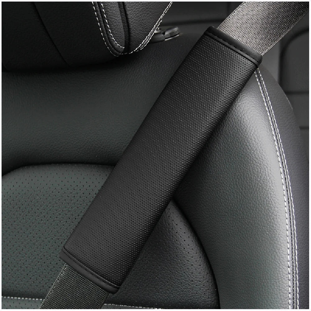 Gros plan d'une housse de ceinture en cuir PU noir embossée pour siège de voiture sur un siège gris foncé.