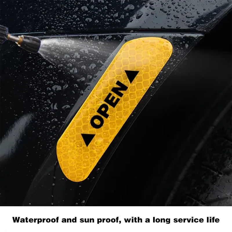 Yellow reflective decal with an open arrow symbol applied to a black car door.