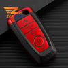 A red multi-function key fob holder with several buttons is shown on a dark surface.