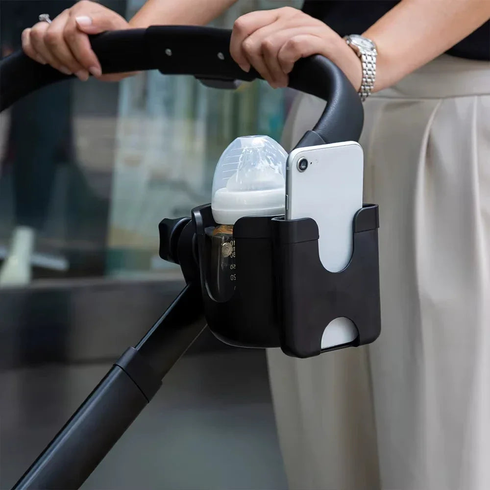 Un appareil multifonction pour tasse et support de téléphone noir est tenu par une personne.