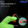 Une main portant un gant vert lime utilise un couteau utilitaire orange pour couper du film sur une surface sombre.