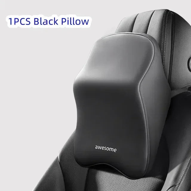 A single black pillow with the word awesome printed on it, shown in close-up against a dark gray chair.
