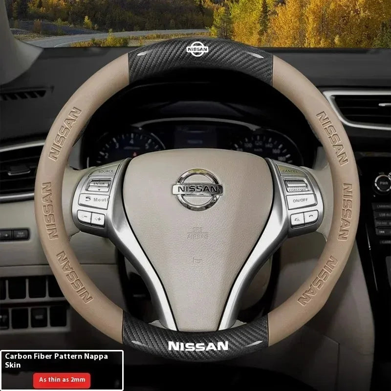 Close-up of a beige Nissan steering wheel with carbon fiber patterned grips and leather wrapping.