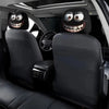 Two black car seat headrest covers with decorative smiling faces installed in a vehicle interior.