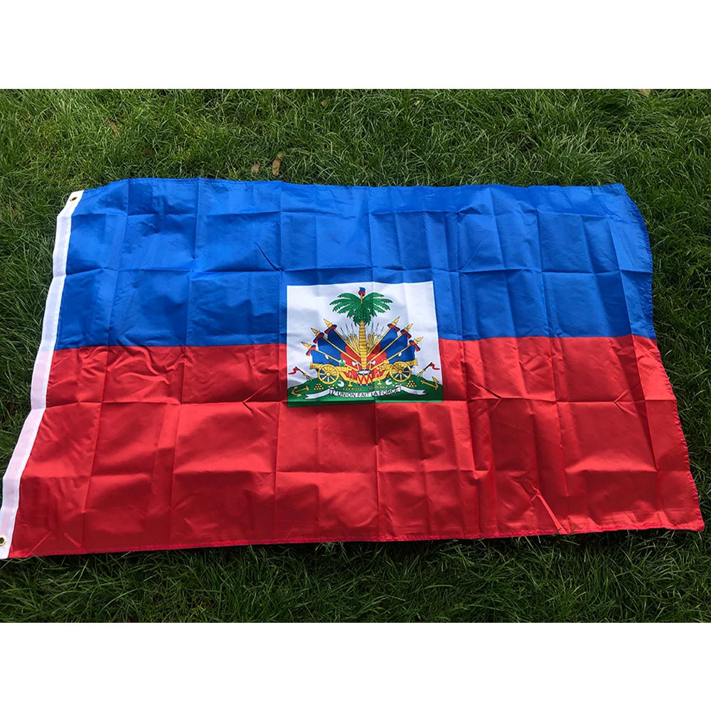 A double-sided polyester flag of Haiti featuring the national colors and coat of arms displayed on a green lawn.