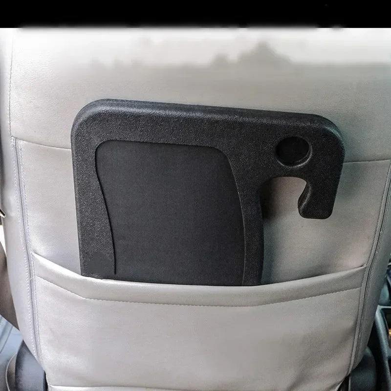 Ein schwarzer multifunktionaler Organizer-Tray ist an einem hellgrauen Autsitz oder Stuhl montiert.