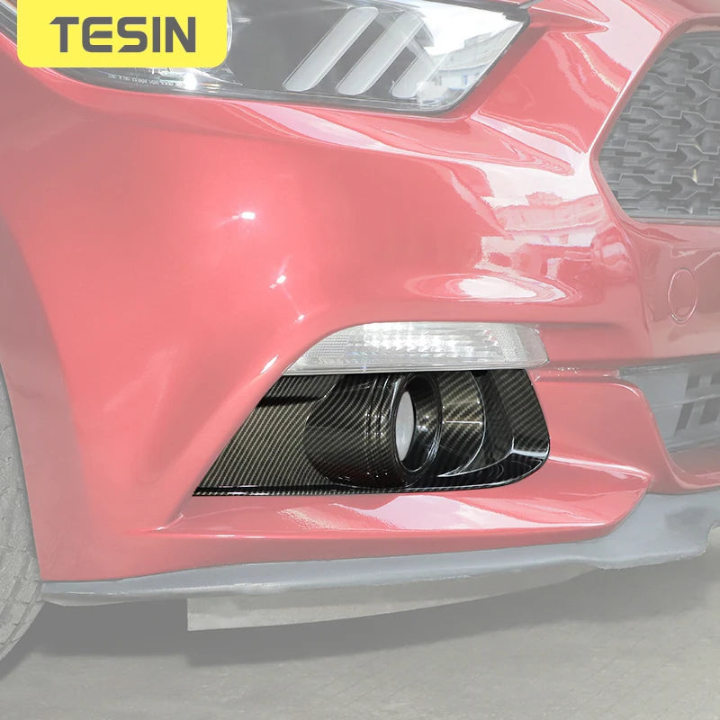 Primer plano de el parachoques delantero rojo de un Ford Mustang con moldura de luces antiniebla de fibra de carbono.