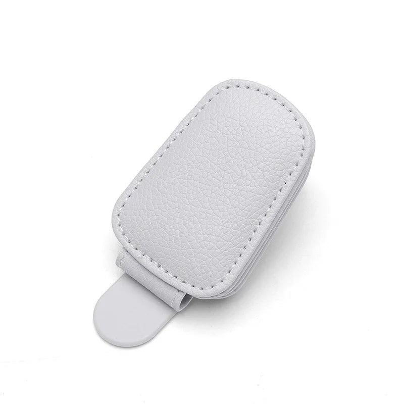 A white magnetic leather sunglasses holder designed for car sun visors.