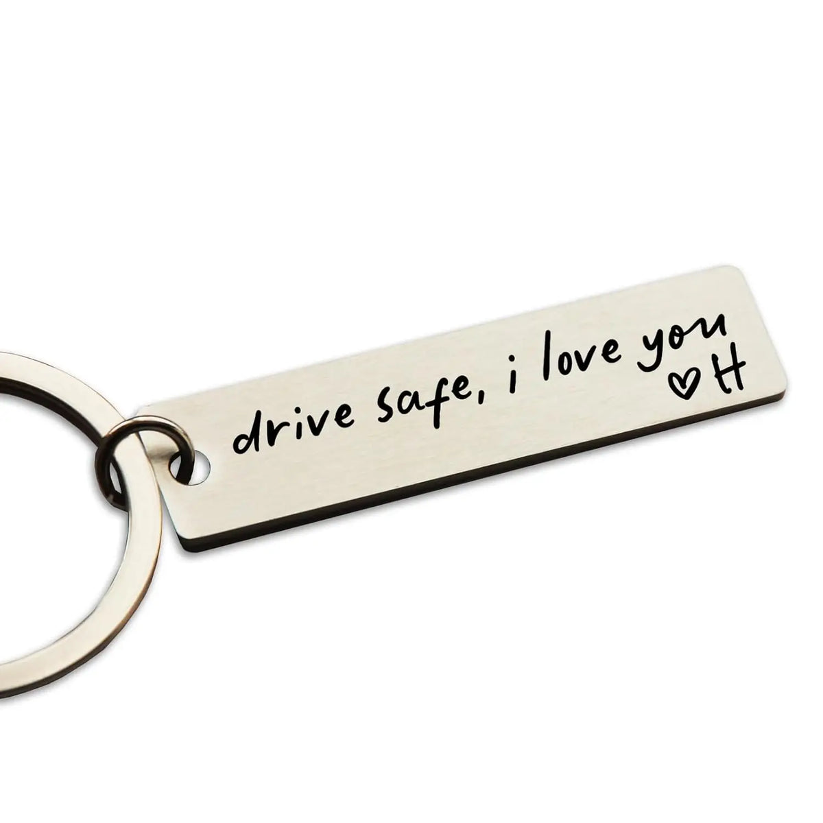 A stainless steel keychain tag engraved with the message drive safe i love you and a heart symbol.