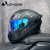 Un casque de moto modulaire noir DOT avec une visière bleue posé sur un siège en cuir noir.