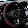A close-up view of a black steering wheel with a maroon PU carbon fiber cover inside a car interior.