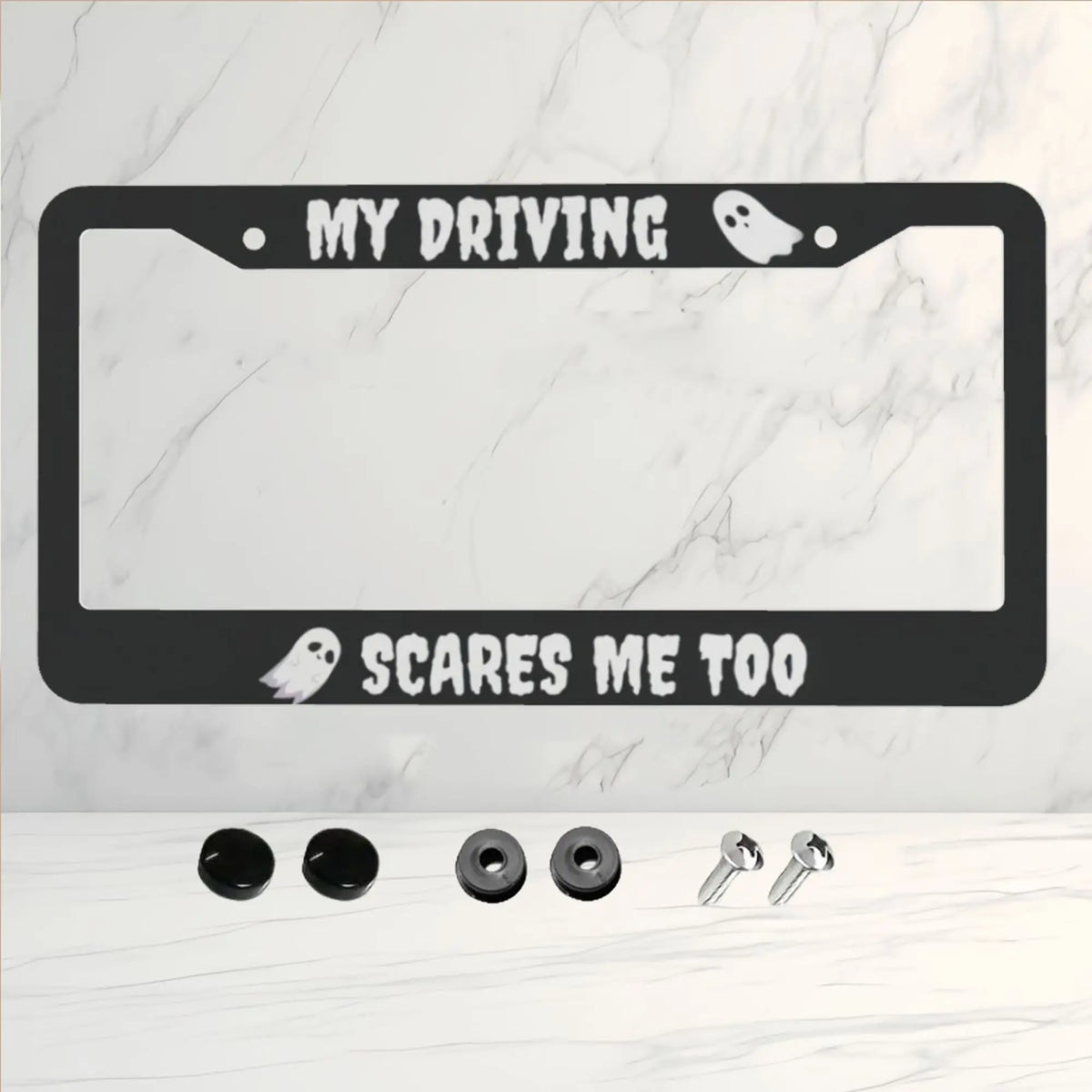 A black aluminum license plate frame with the text MY DRIVING SCARES ME TOO and two silhouette icons.