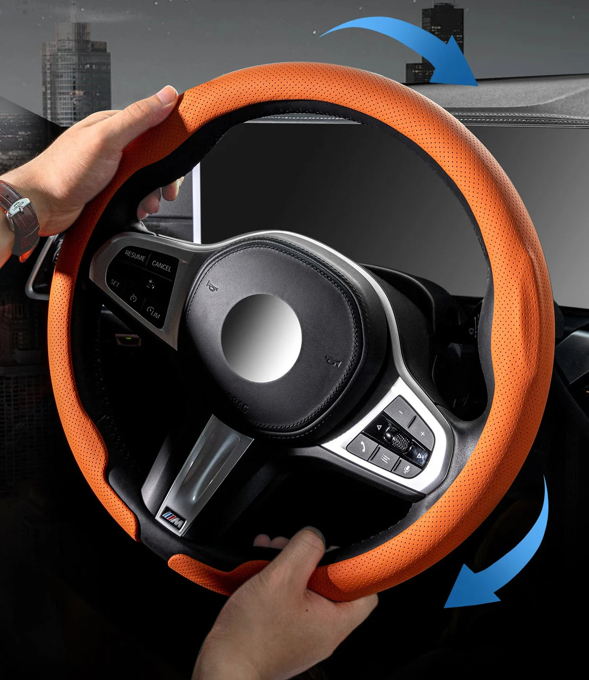 Eine Hand hält eine orangefarbene Lenkradabdeckung eines Autos, die das Interieur und die Bedienelemente zeigt.