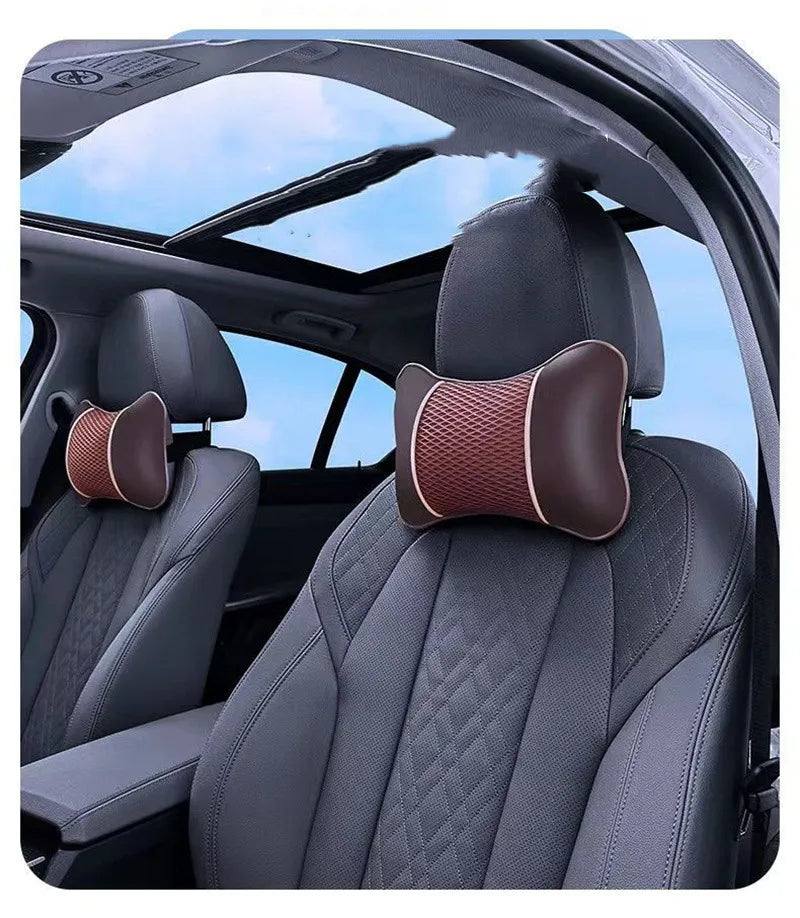 A close-up view of a dark gray car seat headrest with a brown padded pillow for neck comfort.