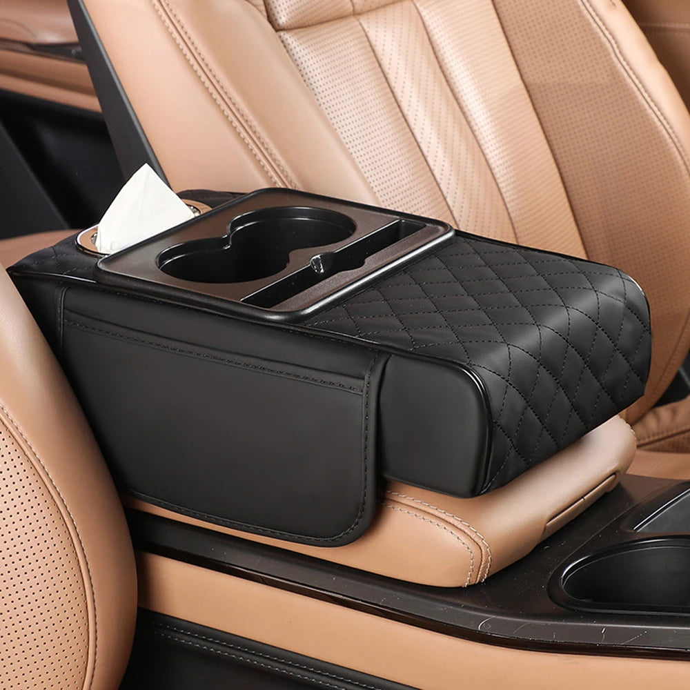 A black multifunctional car armrest cushion with a tissue holder is placed on a tan leather car seat.