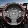 Close-up view of a Lexus steering wheel with red carbon fiber accents and controls.