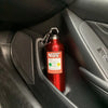 A red insulated stainless steel travel kettle hanging in a car interior door panel.