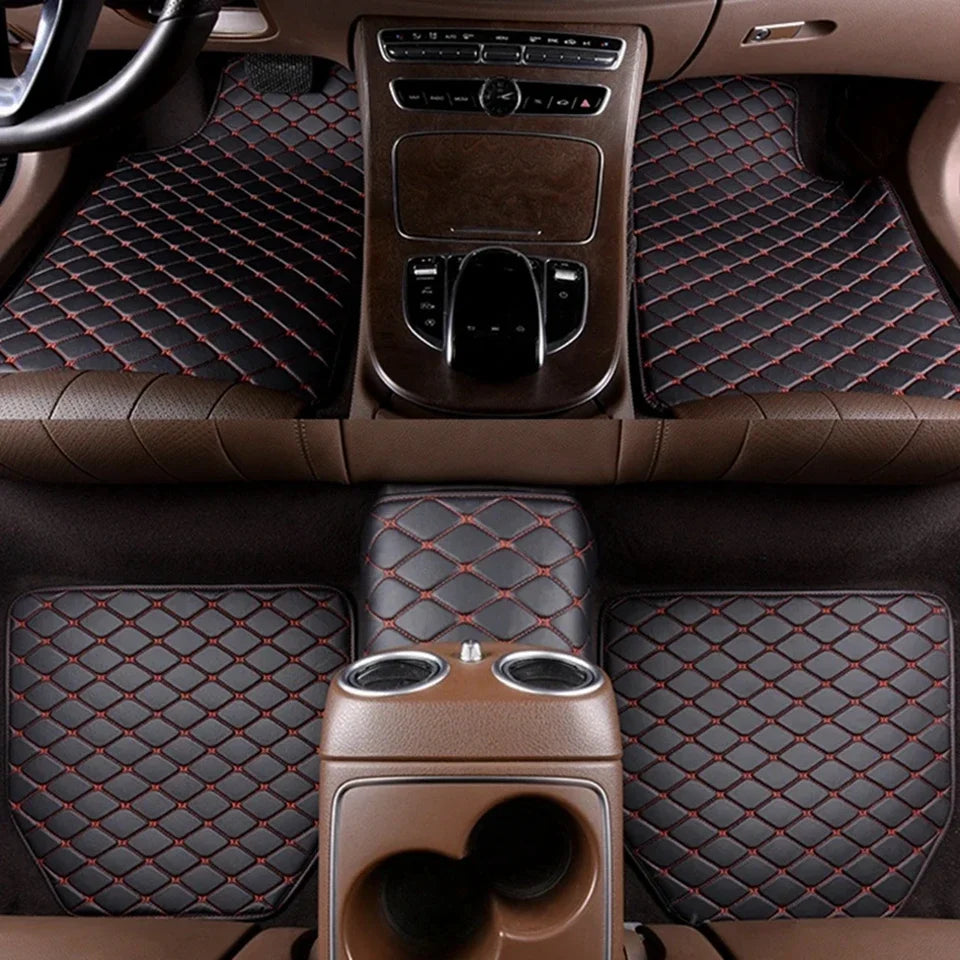 Interior view of a car showing leather floor mats and a center console with controls.