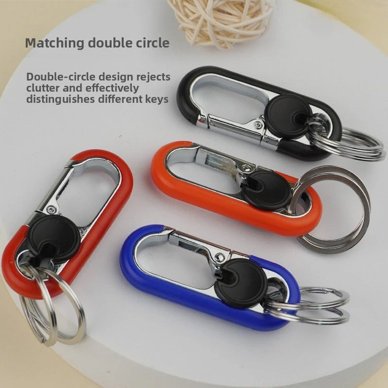 Three different colored double-circle design lock carabiner keychains displayed on a white surface.